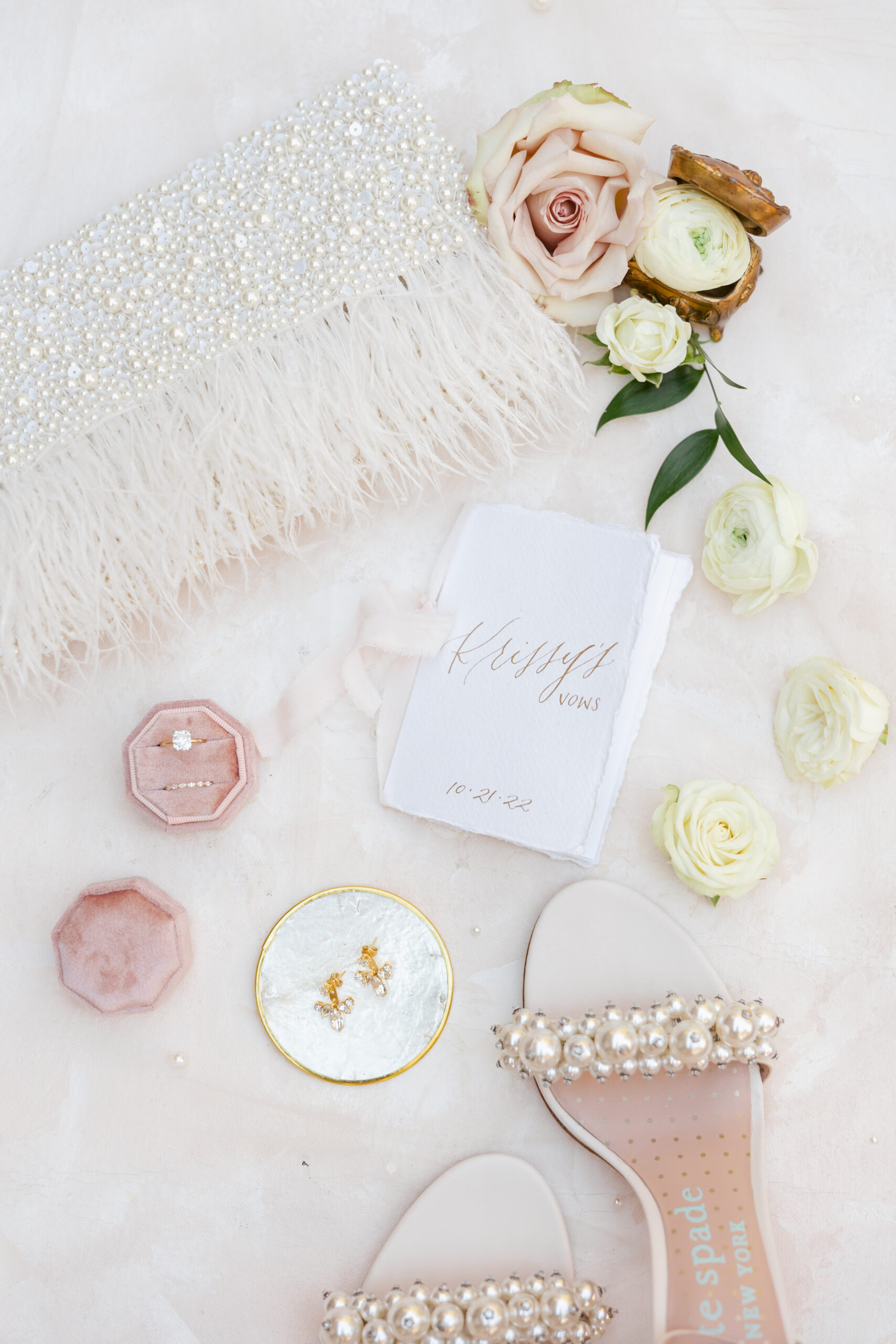 pink ring box, pearl shoes, and calligraphy wedding vows 