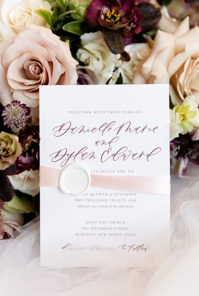 Elegant wedding invitation with calligraphy, styled with blush and burgundy flowers—an example of partnering with wedding planners as a calligrapher.







