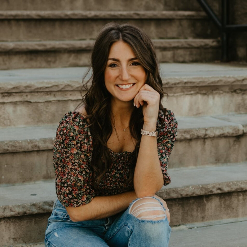 Smiling woman sitting on outdoor steps, representing confidence and growth with pricing strategies for stationers