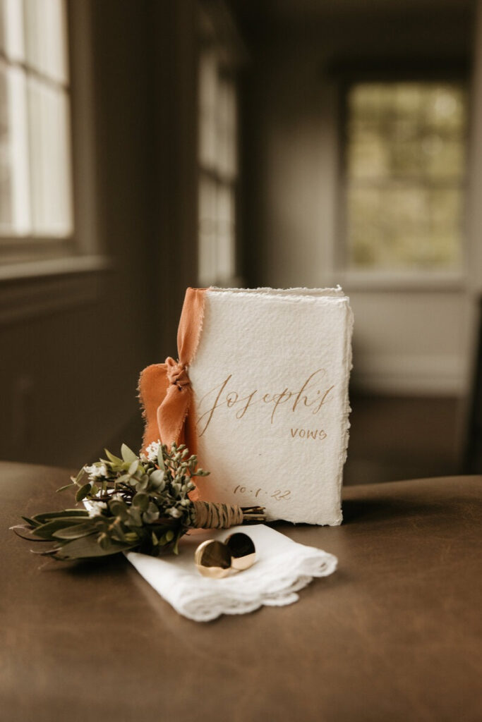 Custom vow book with florals and rings, a product idea for what to offer during slow season.